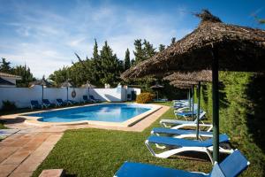 科尼尔-德拉弗龙特拉凯博罗氏旅馆的一个带椅子和草伞的游泳池