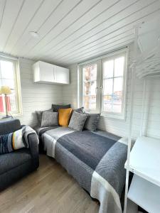 乌尔里瑟港Lyckan - Minihus i lantlig miljö的一张位于配有沙发和窗户的房间的床铺