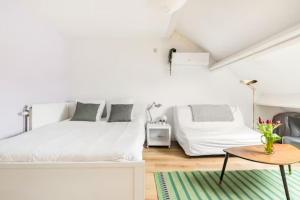特尔菲伦African heritage Tervuren的白色卧室配有两张床和一张桌子