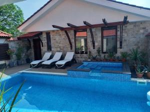 维丁Stariya oreh pool & garden的房屋旁带椅子的游泳池