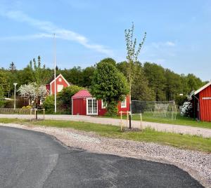 乌尔里瑟港Lyckan - Minihus i lantlig miljö的一条空的公路,有红谷仓和栅栏