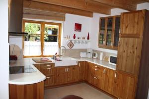 维斯马Ferienhaus-am-Kuhmoor的厨房配有木制橱柜和白色台面