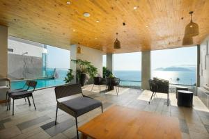 芽庄MySea Panorama Nha Trang Superview Apartments的客厅设有游泳池、桌子和椅子