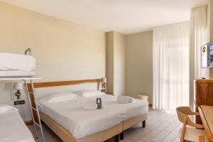 索托马里纳B&B Hotel Chioggia Airone的配有一张床和一张书桌的酒店客房
