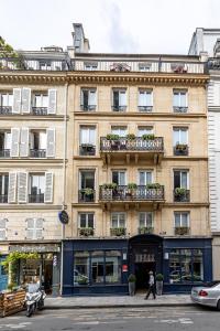 巴黎迪瓦歌剧院酒店的街上的一座建筑,前面的人在街上行走