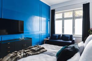 柏林165m2 Downtown Family Suite 5BR, 3Bath, kids room, 11min Alexanderplatz的蓝色的卧室设有床、电视和椅子