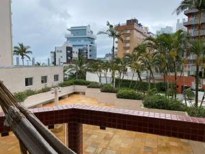 马蒂尼奥斯Apto todo equipado em Caiobá há 50m do mar的阳台享有棕榈树城市的景致。