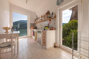 Colle di ToraLetizia lake house panoramic view的一间带大窗户和阳台的厨房