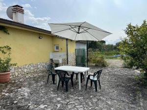 奥托纳Mini House da Maria的一张白色的桌子和椅子,配有雨伞