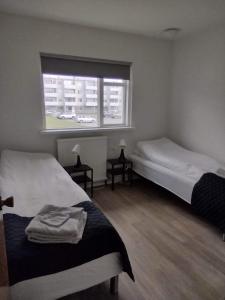 胡萨维克Guesthouse Maddy的一间卧室设有两张床和一个带汽车的窗户。