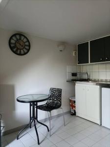 弗兰奎维尔-圣皮尔Agréable et paisible studio的厨房配有桌子、椅子和时钟
