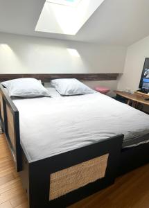 图卢兹Appartement au centre de Toulouse的一张配有白色床单和枕头的大床