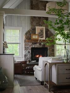 肯尼邦克港希登庞德度假村的客厅设有石制壁炉和白色椅子