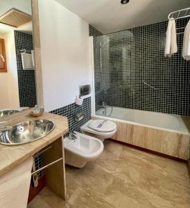 隆达阿希尼普酒店的浴室配有盥洗盆、卫生间和浴缸。