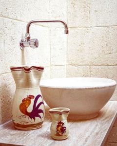 圣维托诺曼Casa vintage da Nonna Maria的两个花瓶坐在一个水槽旁边的柜台上