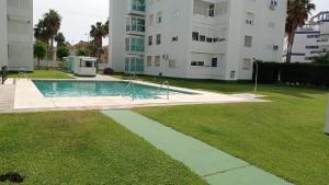 圣玛丽亚港APARTAMENTO GENOVEVA PLAYA - ValdelagranaCadizCom的一座游泳池,位于一座建筑旁的院子内