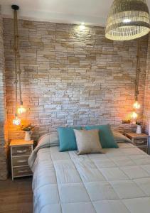 奥利瓦Apartamento Playa Oliva Deluxe的一间卧室设有一张带砖墙的大床