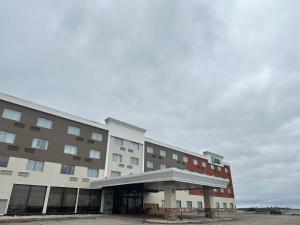 大瀑布城Holiday Inn Express Big Rapids, an IHG Hotel的酒店大楼前面设有停车场