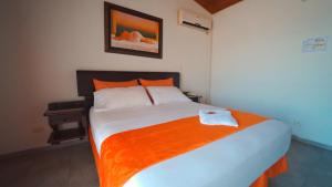 约帕尔Hotel el Atajo的一间卧室配有一张带橙色毯子的大床