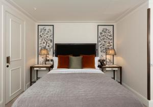 伦敦The City of London Club的一间卧室配有一张带橙色枕头的大床
