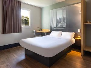 雷恩B&B HOTEL Rennes Sud Chantepie的酒店客房设有一张大床和一张桌子。