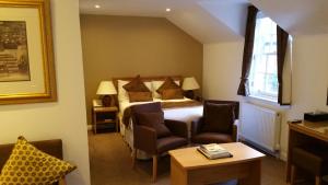 爱丁堡皇家苏格兰俱乐部酒店的酒店客房,配有一张床和两把椅子