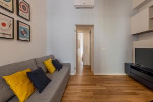 米兰BnButler - Sebenico, 28 - Nuovissimo Appartamento in Isola的客厅配有灰色的沙发和黄色的枕头。