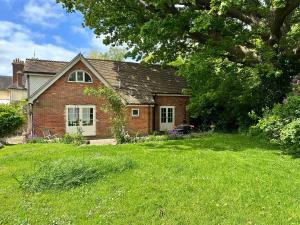 海尔舍姆Peaceful cottage with private garden的绿色草坪庭院中的砖屋