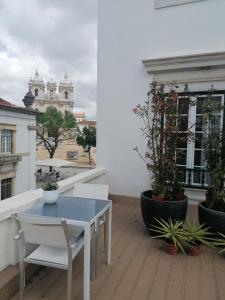 阿尔科巴萨罗西奥阿尔科巴萨旅馆的种植了植物的阳台配有白色的桌椅