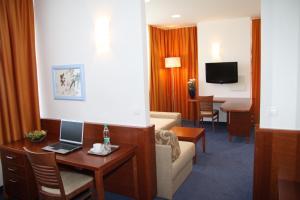 克拉尼Garni Hotel Azul的酒店客房设有一张沙发和一张带笔记本电脑的桌子。