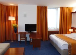 克拉尼Garni Hotel Azul的酒店客房配有一张床和一张书桌及一台电视