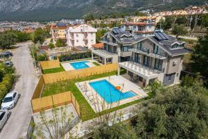 费特希耶Villa Lina Ölüdeniz/Fethiye的享有带游泳池的房屋的空中景致