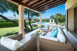 波连斯萨Owl Booking Villa Siquier - Luxury Retreat with Mountain Views的一个带柳条家具的庭院,享有游泳池的景色