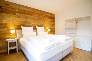戈斯拉尔Schiefer Suite Hotel & Apartments的卧室配有白色的床和木墙