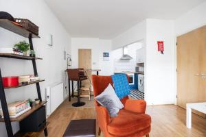 都柏林Peaceful 1 bedroom apartment in Portobello, Dublin的一个带橙色椅子的客厅和一个厨房