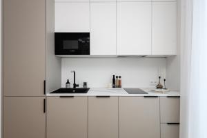 派尔努Bob W Pärnu的白色的厨房配有白色橱柜和水槽