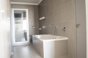 斯瓦科普蒙德Bay View Resort Hotel Namibia的浴室配有白色浴缸和淋浴。