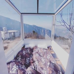 马恩迪Stargazing Glass Lodge Himachal Pradesh Thachi的一张位于带大窗户的房间内的床铺