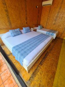 图斯特拉古铁雷斯Hotel Momotus的一间卧室配有两张带蓝色枕头的床