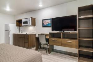 赫米蒂奇WoodSpring Suites Hermitage - Nashville Airport的一间卧室配有一张床和一张书桌及电视