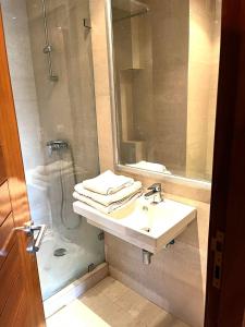 诺阿瑟Short Stay Apartment aéroport casablanca的一间带水槽、淋浴和镜子的浴室