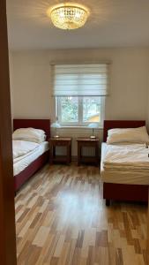 图尔恩Ferienzimmer zwischen Wien und Tulln的一间卧室设有两张床和一个带吊灯的窗户。
