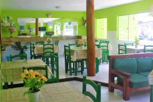 塞古罗港Hotel Kalifornia的餐厅拥有绿色的墙壁和桌椅