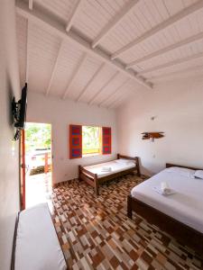 贾丁Hosteria El Paraiso的一间设有两张床和一台电视的房间