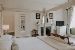 阿灵顿阿灵顿庄园酒店的卧室配有白色的床和壁炉