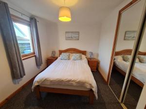 洛赫吉尔普黑德Kings Reach - Crinan Cottage的一间卧室配有一张床和一面大镜子