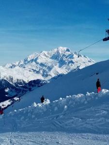 阿雷什L'appartement LES BOSSONS en lisière de forêt dans le chalet Génépi的两个人站在雪覆盖的山上