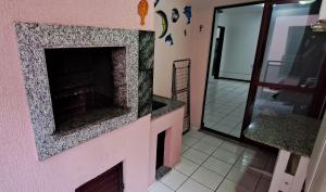 伊塔佩马Descanso a 100m do Mar的客厅设有粉红色墙壁上的壁炉