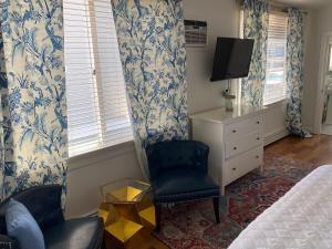 奥克布拉夫斯Inkwell Beach Cottage的一间卧室配有一张床、一把椅子和电视。