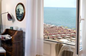 维亚雷焦帕里斯酒店的带窗户的客房享有海滩美景